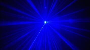 Closeup of shining blue light with beam. Brightness in dark room. Spiral design forming in event. video