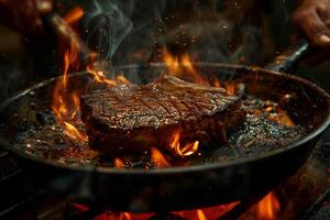 A steak is being cooked on a grill with flames photo