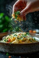 A person sprinkling salt on a plate of pasta photo