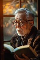 An old man with glasses reading a book photo