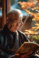An old man in a black robe reading a book photo