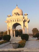 A white marble structure with a dome on top photo