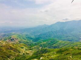 A view of a mountain range with a kite flying in the sky photo
