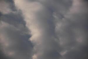 A plane flying through the clouds with a dark sky photo