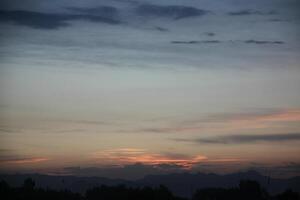A plane flying in the sky at sunset photo