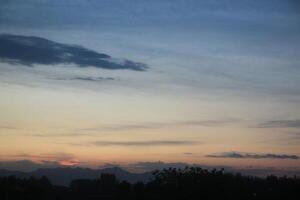 A plane flying over a city at sunset photo
