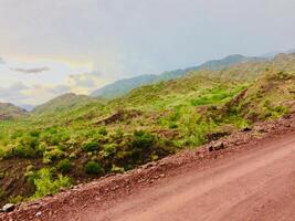 A dirt road with a mountain in the background photo