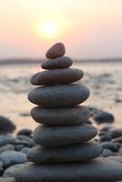 A stack of stones on the beach at sunset. photo