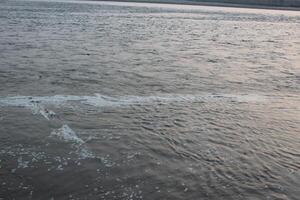 A person is flying a kite in the water photo
