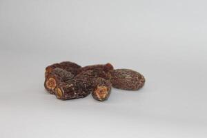 A pile of dried dates on a white surface photo