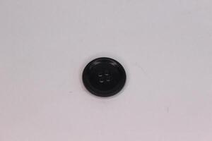 A black button on a white surface photo