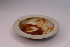 A white bowl with a small amount of food in it photo