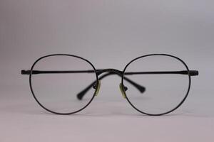 A pair of glasses with a black rim and yellow lenses photo