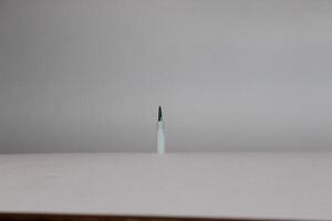 A single white toothbrush on a white surface photo