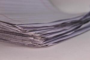 A stack of papers on a white surface photo
