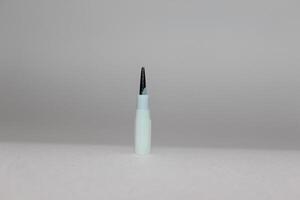 A small white and black pen on a white surface photo