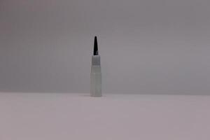 A small white and black pen on a white surface photo