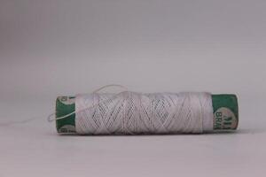 A spool of white thread on a table photo