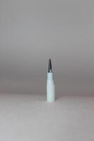 A white pencil head is sticking out of a wall photo