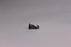 A small silver ring sitting on top of a white surface photo