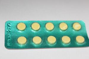 A pack of pills with yellow pills on top photo