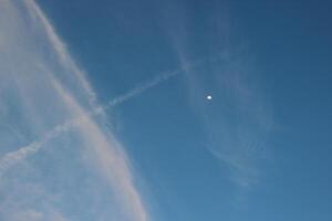 A plane flying in the sky with a contrail photo