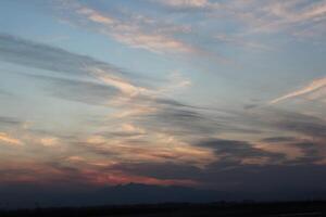 A plane flying in the sky with a sunset in the background photo