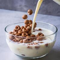 A bowl of cereal with milk being poured into it photo