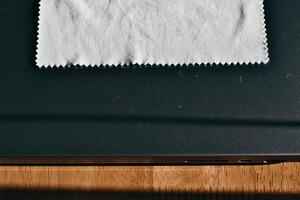 Cleaning Cloth on Laptop on Wooden Surface photo