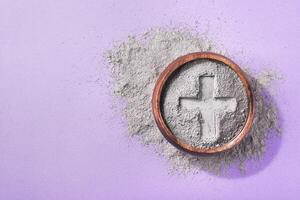 Cross imprint in gray ash on purple background. Ash Wednesday, copy space photo