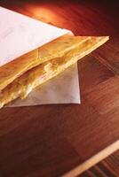 thin pancakes with ham and cheese in an envelope are placed on a serving surface in a restaurant photo
