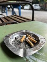 a cigarette is sitting on a metal tray on a table photo