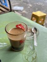 a cup of tubruk coffee sitting on a table photo
