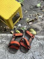 a pair of sandals and a yellow stool photo