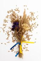 A bouquet of dried flowers with a yellow and blue ribbon of the flag of Ukraine on the background photo