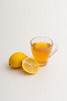 cup of tea and lemons on white table photo