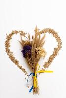 A bouquet of dried flowers with a yellow and blue ribbon of the flag of Ukraine on the background photo