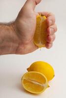 hand squeezing lemon white background photo