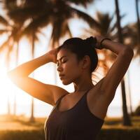 A woman is standing in a field with palm trees in the background photo