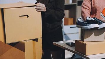 A woman is holding a box with shoes and a pair of shoes video