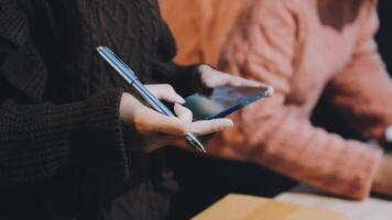 A person holding a pen and a cell phone video