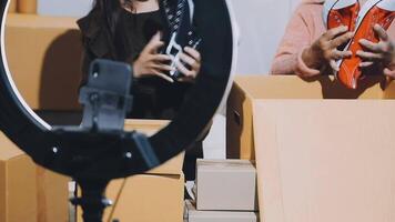A woman holding a camera and a shoe box video