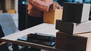 A stack of boxes on a table with a person sitting in front of it video