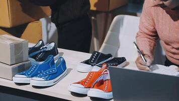 uma homem é trabalhando em dele computador portátil enquanto sentado às uma mesa com de várias pares do sapatos video