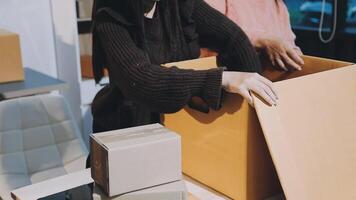 Two people are packing boxes in a room video