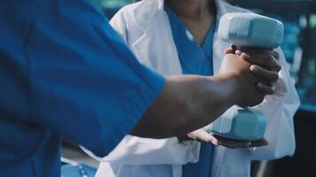 A doctor is holding a dumbbell in front of another person video