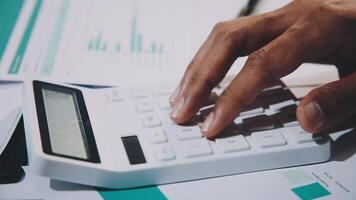 A person's hand is on a calculator and a piece of paper video