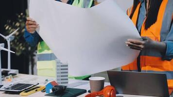 Two people in safety vests holding paper and working on a project video