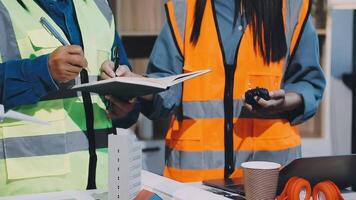 Two people in safety vests are working on a project video