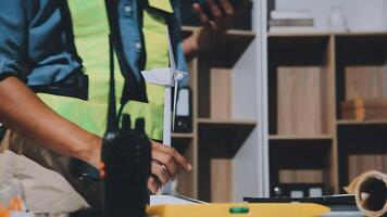 A man in a safety vest is working on a computer video